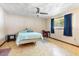 A cozy bedroom with a ceiling fan, carpet flooring, and a large window with ample natural light at 5441 Alderwood St, Spring Hill, FL 34606