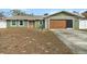 Charming single-story home with a well-maintained lawn, wooden garage door, and inviting front entrance at 5441 Alderwood St, Spring Hill, FL 34606