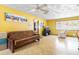 Bright living room featuring vinyl floors, yellow walls, ceiling fan and a large window at 5441 Alderwood St, Spring Hill, FL 34606
