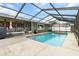 A screened-in pool area, featuring a clear pool and spacious patio with an outdoor grill and plenty of sunshine at 5441 Alderwood St, Spring Hill, FL 34606