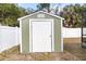 Well-kept backyard shed with a sturdy door, offering practical storage solutions in a tidy, fenced yard at 5441 Alderwood St, Spring Hill, FL 34606
