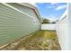 A fenced side yard offering privacy and a glimpse of the home's exterior with its green siding and white trim at 5441 Alderwood St, Spring Hill, FL 34606
