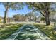 Outdoor shuffleboard court with clear markings and mature trees in a well-maintained community at 6329 Cardinal Crest Dr, New Port Richey, FL 34655