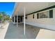 Exterior view of home showing covered parking, window shutters, and view of waterfront area at 6448 W Richard Dr, Weeki Wachee, FL 34607