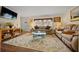 Bright living room with two sofas, a glass coffee table, and hardwood-style flooring at 6448 W Richard Dr, Weeki Wachee, FL 34607