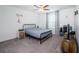 Bright bedroom with a metal-framed bed, white trim, and patterned curtains at 6482 Beverly Hills Dr, Zephyrhills, FL 33541