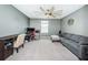 Neutral-toned bedroom showcasing a desk, chair, couch and an oversized ceiling fan at 6482 Beverly Hills Dr, Zephyrhills, FL 33541
