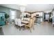 Open-concept dining area with chandelier, a dining table set for eight, and bright neutral decor at 6482 Beverly Hills Dr, Zephyrhills, FL 33541