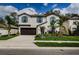 Charming two-story home featuring blue shutters, a well-manicured lawn, and a two car garage at 6482 Beverly Hills Dr, Zephyrhills, FL 33541