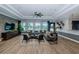 Living room with hardwood floors, comfortable seating, and a view of the pool at 6482 Beverly Hills Dr, Zephyrhills, FL 33541