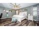 Stylishly furnished main bedroom with hardwood floors, a large ceiling fan, and ample natural light at 6482 Beverly Hills Dr, Zephyrhills, FL 33541