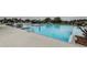 Spacious pool area surrounded by lounge chairs, lush landscaping, and clear blue water, perfect for relaxation and recreation at 6482 Beverly Hills Dr, Zephyrhills, FL 33541