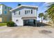 Stilt home with a covered carport, a manicured shrub and waterfront views on a sunny day at 6503 Driftwood Dr, Hudson, FL 34667