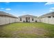 Large backyard with a patio area featuring a table, chairs, and black umbrella, surrounded by a white fence at 6644 Longboat Dr, Brooksville, FL 34604