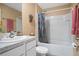 Well-lit bathroom with a white sink, cabinets, and a shower-tub combo with floral accents at 6644 Longboat Dr, Brooksville, FL 34604