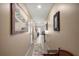 Hallway featuring neutral-toned walls, tiled floors, and decorative artwork leading to other rooms at 6644 Longboat Dr, Brooksville, FL 34604
