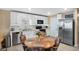 Bright eat-in kitchen with white cabinets, stainless steel appliances, and a large dining table at 6644 Longboat Dr, Brooksville, FL 34604