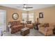 Comfortable living room with cozy furniture, including a sofa, two chairs, and a ceiling fan at 6644 Longboat Dr, Brooksville, FL 34604