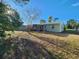Large backyard featuring a patio, mature landscaping, and wooden fence at 7028 Merrick Ln, Spring Hill, FL 34606