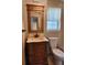 Bathroom showcasing a decorative mirror, ornate vanity, toilet and window at 7028 Merrick Ln, Spring Hill, FL 34606