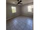 Bedroom with tile flooring, neutral walls, ceiling fan and two windows offering lots of light at 7028 Merrick Ln, Spring Hill, FL 34606