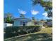 Exterior shot of home, shrubbery, beautiful skies, and lawn at 7028 Merrick Ln, Spring Hill, FL 34606