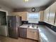 Well-lit kitchen features white cabinets, stainless steel appliances, and ample counter space at 7028 Merrick Ln, Spring Hill, FL 34606