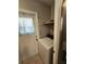 This laundry room features a white washing machine, a door with curtains, and a shelf above the machine at 7028 Merrick Ln, Spring Hill, FL 34606