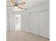 Neutral carpeted bedroom features sliding closet and doorway access at 7048 Oberon Ave, Spring Hill, FL 34608