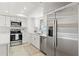 Bright kitchen features stainless steel appliances, white cabinetry, and tile flooring at 7048 Oberon Ave, Spring Hill, FL 34608