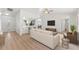 Bright, open living room featuring a view into kitchen with bar seating and neutral decor throughout at 7048 Oberon Ave, Spring Hill, FL 34608