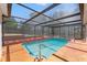 Screened-in pool area with beautiful landscaping and a relaxing atmosphere at 7048 Oberon Ave, Spring Hill, FL 34608