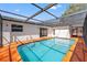 The screened-in pool is surrounded by an orange concrete deck and is easily accessible from the home's interior at 7048 Oberon Ave, Spring Hill, FL 34608