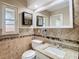 Bathroom featuring custom tile design, granite vanity and modern sink at 7735 Hawthorn Dr, Port Richey, FL 34668