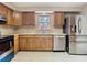 A well-lit kitchen features stainless steel appliances, light granite countertops, and wooden cabinets at 7735 Hawthorn Dr, Port Richey, FL 34668