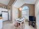 Bright dining area with white chairs, a modern light fixture, and a sunlit window at 7912 Trail Run Loop, New Port Richey, FL 34653