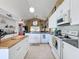 Bright kitchen featuring white cabinetry, an island, and stainless steel appliances at 7912 Trail Run Loop, New Port Richey, FL 34653