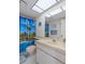 Bathroom featuring a shower with a tropical-themed curtain, light cabinets and a framed mirror at 8211 Brent St # 816, Port Richey, FL 34668