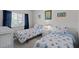Bright bedroom features twin beds with seashell bedding, white furniture, and a window with natural light at 8211 Brent St # 816, Port Richey, FL 34668