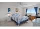 Bright bedroom features a ceiling fan, neutral carpet, and a window with blue curtains at 8211 Brent St # 816, Port Richey, FL 34668