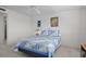 Bright bedroom features a ceiling fan, neutral carpet, and a window with blue curtains at 8211 Brent St # 816, Port Richey, FL 34668