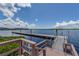 A wooden dock extends into a body of water under a blue sky, with buildings in the background at 8211 Brent St # 816, Port Richey, FL 34668