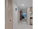 Clean hallway offering a glimpse of the living room and kitchen area, featuring white tile flooring at 8211 Brent St # 816, Port Richey, FL 34668