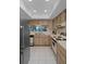 Modern kitchen with wooden cabinets, tile flooring, and essential appliances providing an efficient cooking space at 8211 Brent St # 816, Port Richey, FL 34668