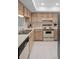 Well-lit kitchen featuring tile flooring, wooden cabinets, and essential appliances for convenient meal preparation at 8211 Brent St # 816, Port Richey, FL 34668