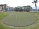 A putting green on a sunny day is surrounded by trees and grass at 8211 Brent St # 816, Port Richey, FL 34668