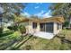 Exterior view of the home featuring a patio and sunroom with backyard greenery at 8420 Winding Wood Dr, Port Richey, FL 34668