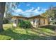 Charming home featuring a sunroom and well-maintained lawn at 8420 Winding Wood Dr, Port Richey, FL 34668