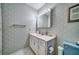 Bathroom offering vanity storage, ample lighting, and light blue patterned walls at 8420 Winding Wood Dr, Port Richey, FL 34668