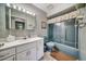 Retro bathroom with a combo tub and shower, a blue toilet, and vanity storage at 8420 Winding Wood Dr, Port Richey, FL 34668